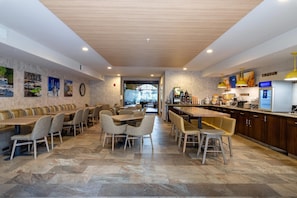 Un restaurant moderne doté d’un long comptoir, de plusieurs espaces de restauration et d’une cuisine ouverte.