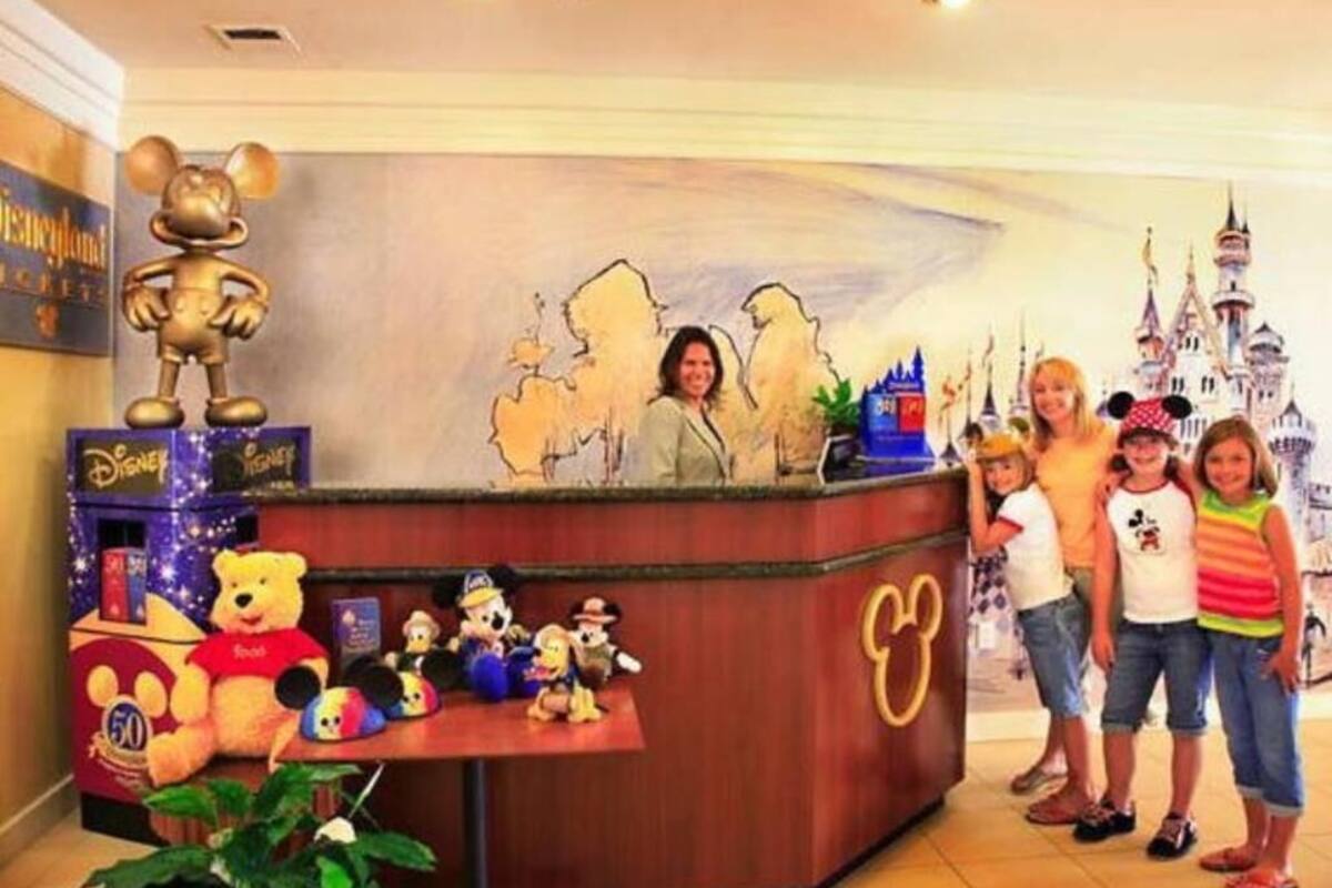 Vastaanottotiski, jonka sisustuksessa on käytetty Disney-teemaa, mukaan lukien suuri Mikki Hiiri -patsas, pehmoleluja ja seinämaalaus, jossa on kuvattuna linna.