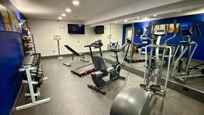 Ein Fitnessstudio mit unterschiedlichen Trainingsgeräten, darunter Laufbänder, Ergometer und Kraftgeräte.