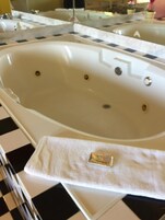 Bañera con ducha, toallas, jabón, shampoo