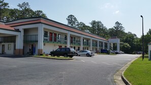 A motel with multiple floors, a parking lot, and a small lawn area.