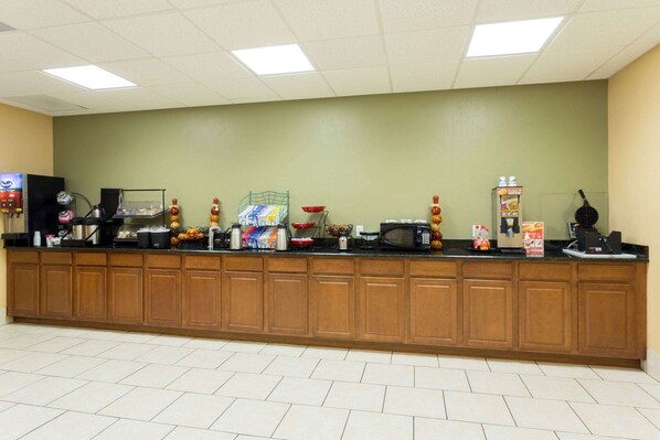 A long counter with various food and drink dispensers, a coffee machine, and a microwave.