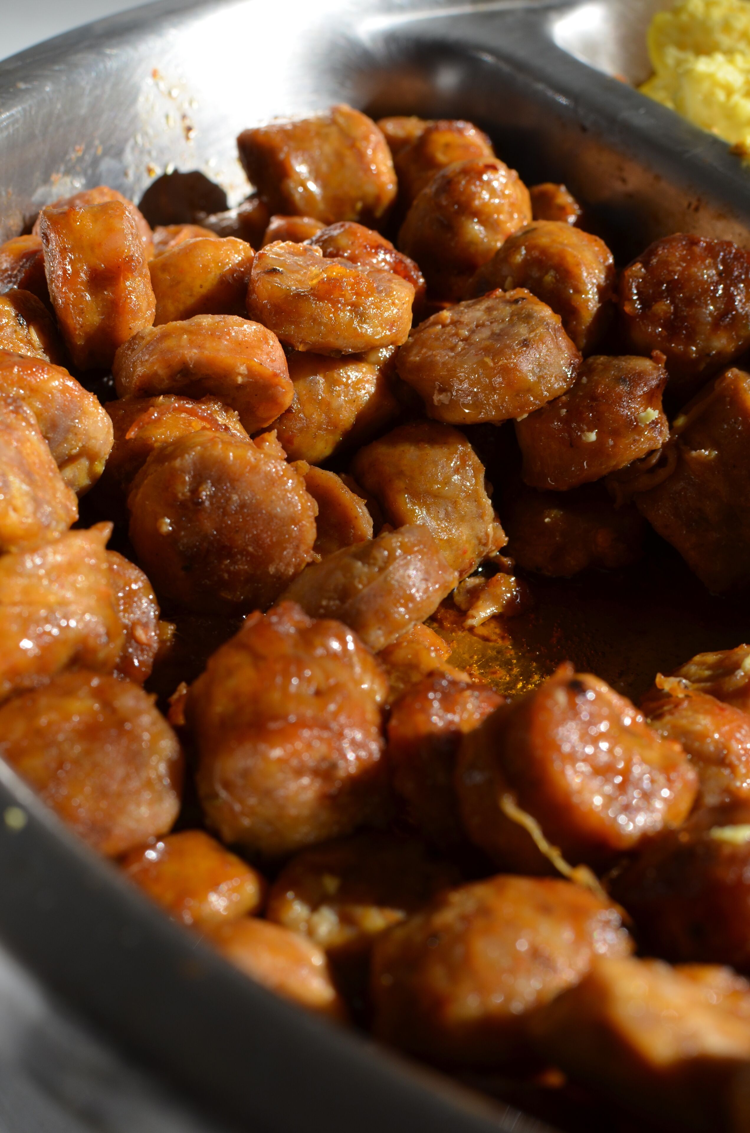 Primer plano de un plato con albóndigas glaseadas en una sartén.