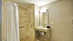 A modern bathroom with a shower, a vanity with a mirror, and a toilet. - Holiday Inn Express Romulus / Detroit Airport by IHG (Romulus)