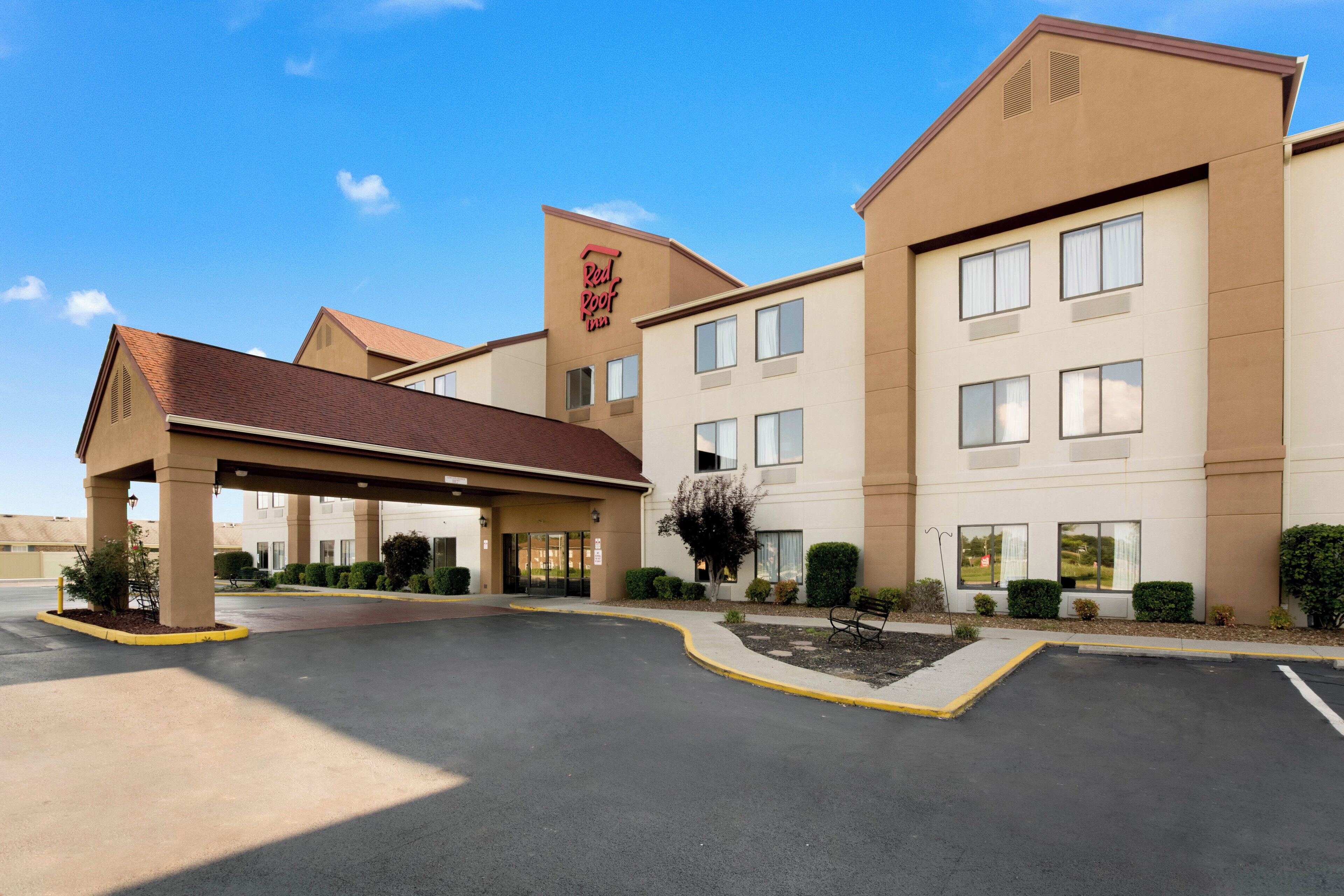 A Red Roof Inn with a covered entrance, multiple windows, and a parking lot.