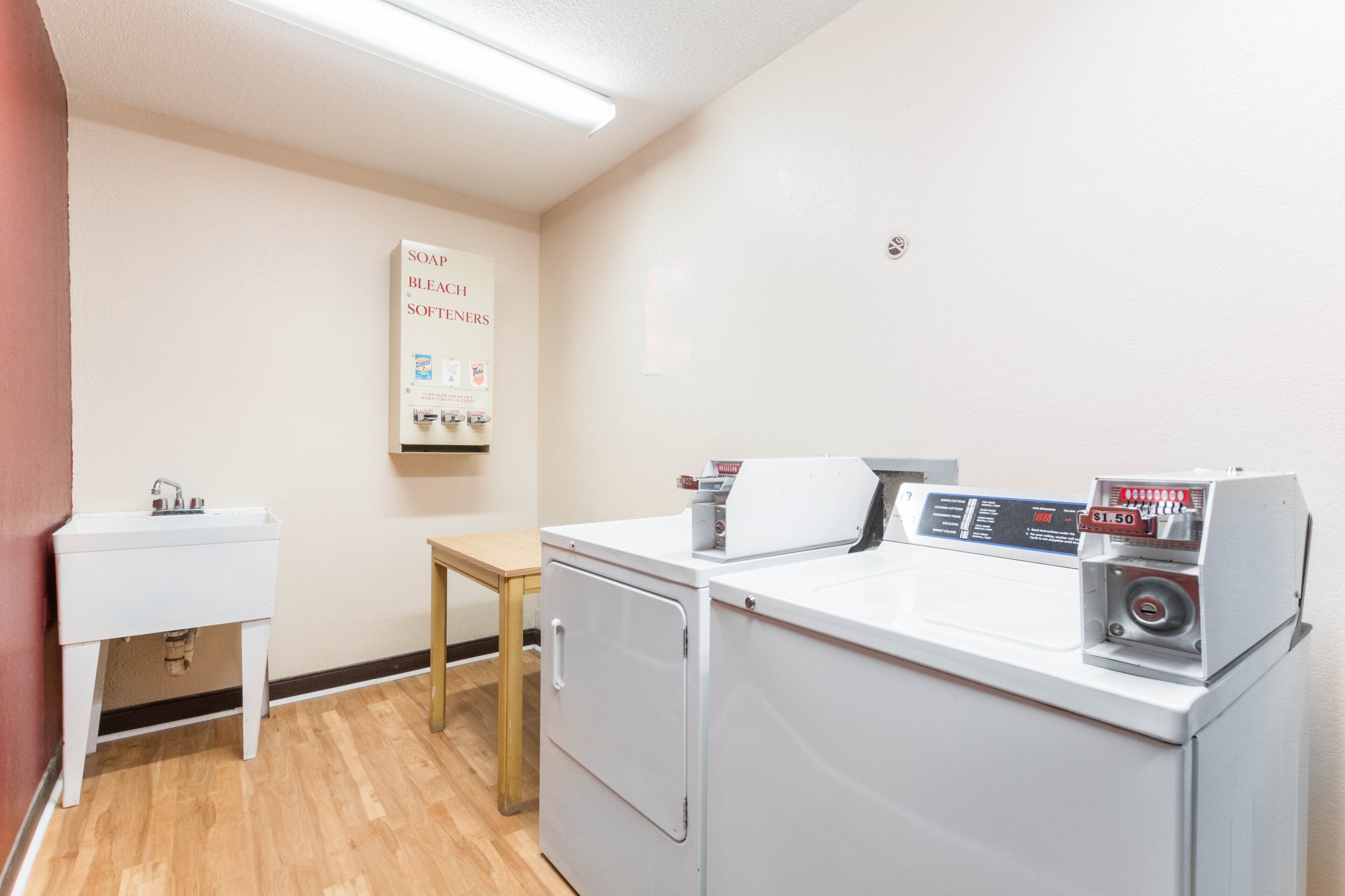 A laundry room with a washing machine, dryer, and a sink.