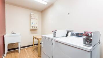 A laundry room with a washing machine, dryer, and a sink.