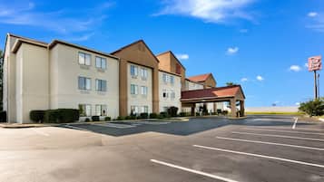 A hotel with a parking lot and a covered entrance.