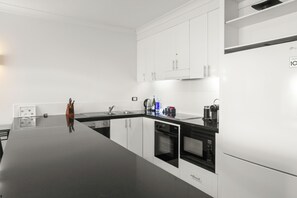 1 Bedroom Beach Front Apartment - Complimentary Parking, WiFi and Daily Beach Yoga | Private kitchen | Full-size fridge, microwave, oven, stovetop