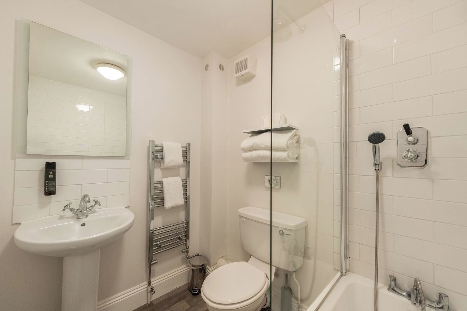A modern bathroom with a sink, toilet, and glass-enclosed shower.