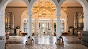 A spacious lobby with high ceilings, arched columns, and hanging chandeliers. - The Ritz-Carlton, St. Thomas (St. Thomas)