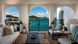 A modern living room with a view of turquoise waters and a hilly landscape. - The Ritz-Carlton, St. Thomas (St. Thomas)