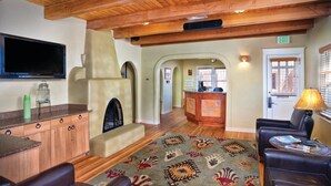 Un hall con chimenea, techo de madera, mostrador de recepción y zona de estar.