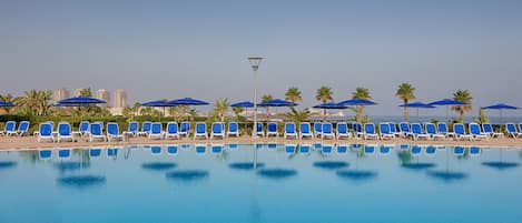 Una piscina cubierta, una piscina al aire libre de temporada, sombrillas