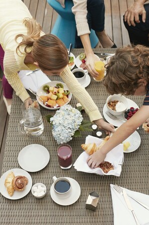 A dining table with plates, cups, and food items.