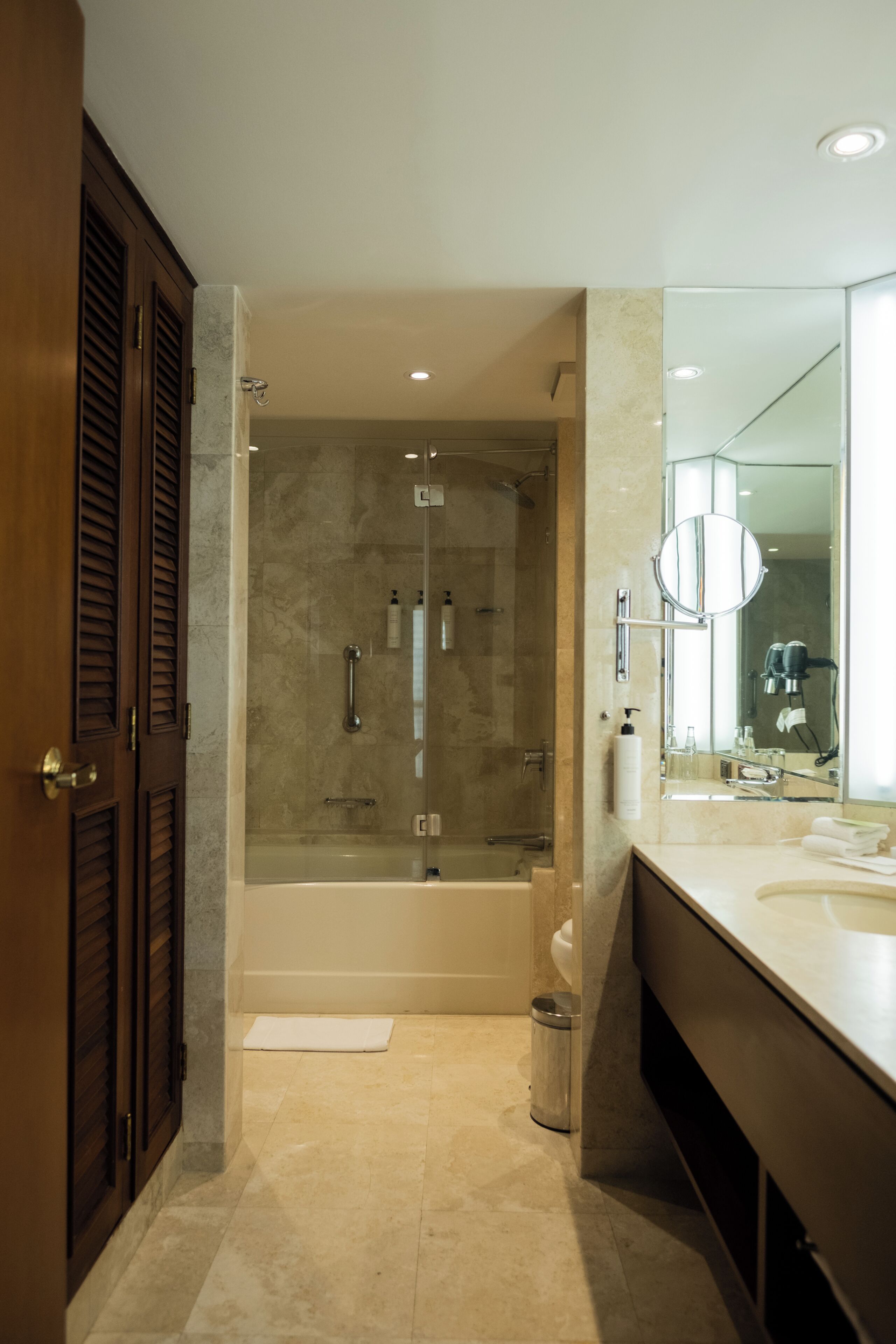 Un baño moderno con ducha de vidrio, un espejo grande y un tocador con lavabo.