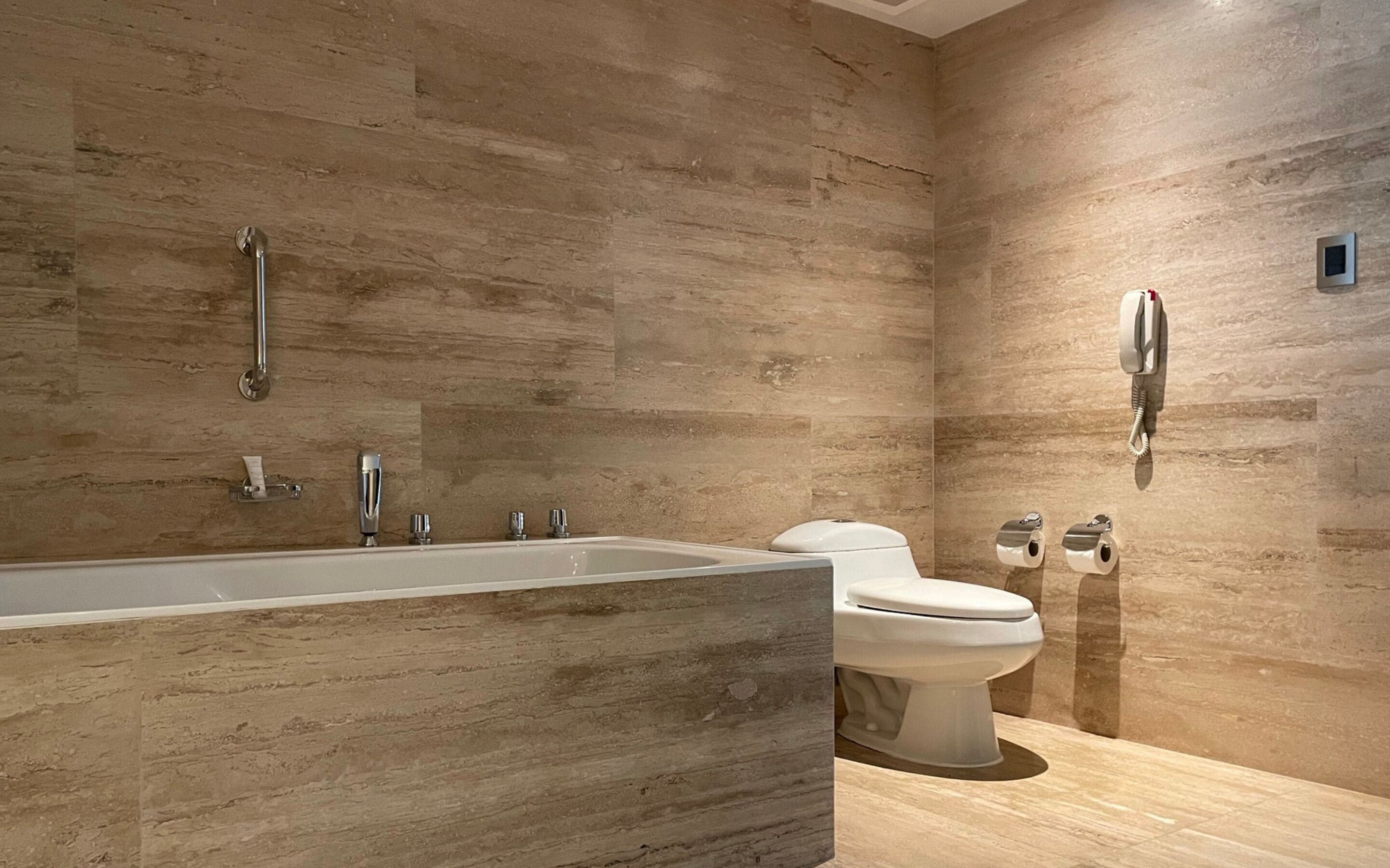 A modern bathroom with a large bathtub, a toilet, and a shower.