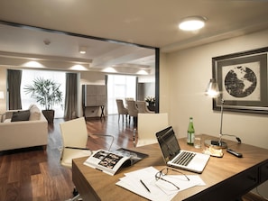 A modern office space with a wooden desk, laptops, and a framed map on the wall.