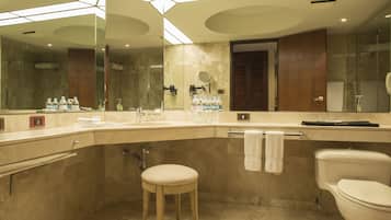 A modern bathroom with a large mirror, a sink, a toilet, and a stool.