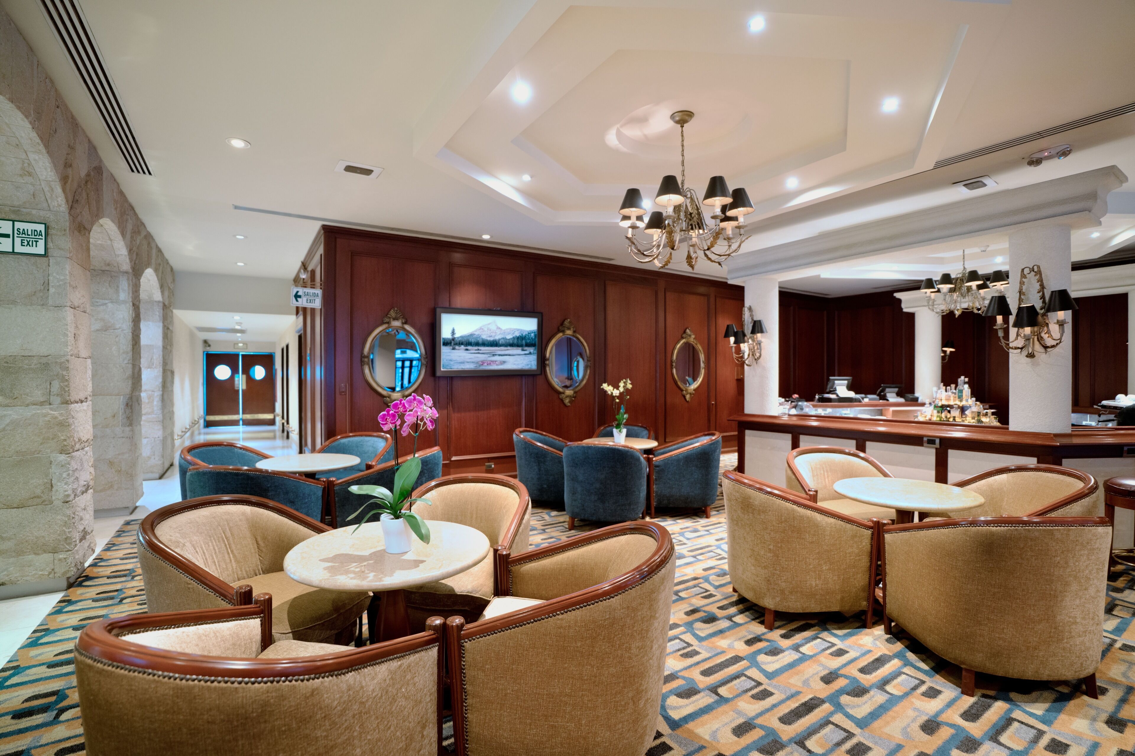 A lobby with seating areas, a television, and a reception desk.