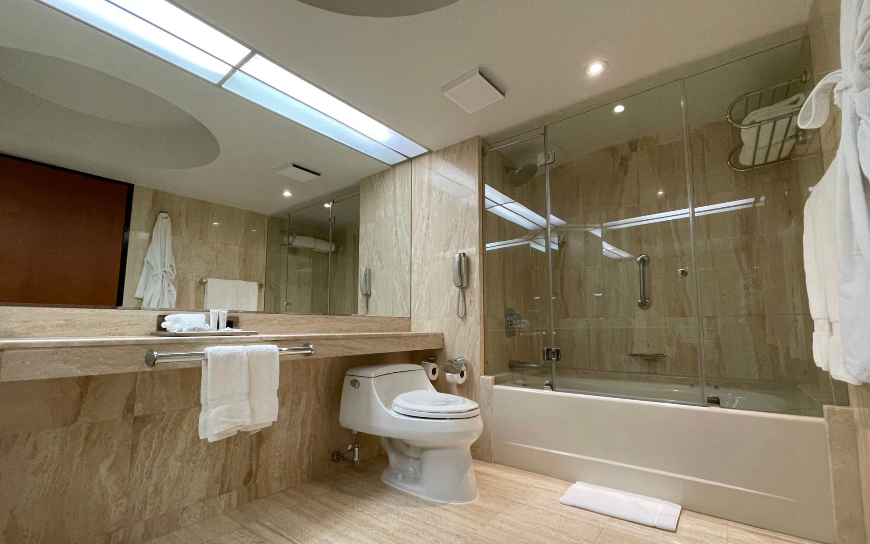 A modern bathroom with a glass-enclosed shower, a toilet, and a bathtub.
