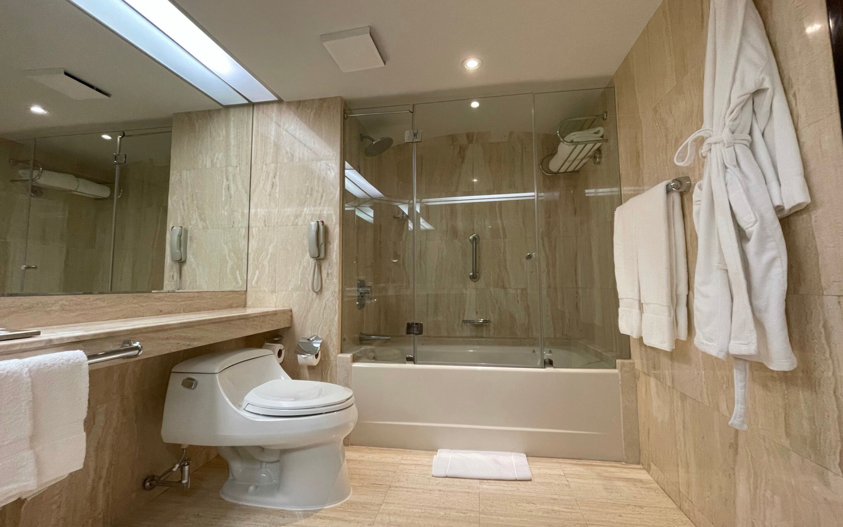 A modern bathroom with a toilet, sink, and bathtub.