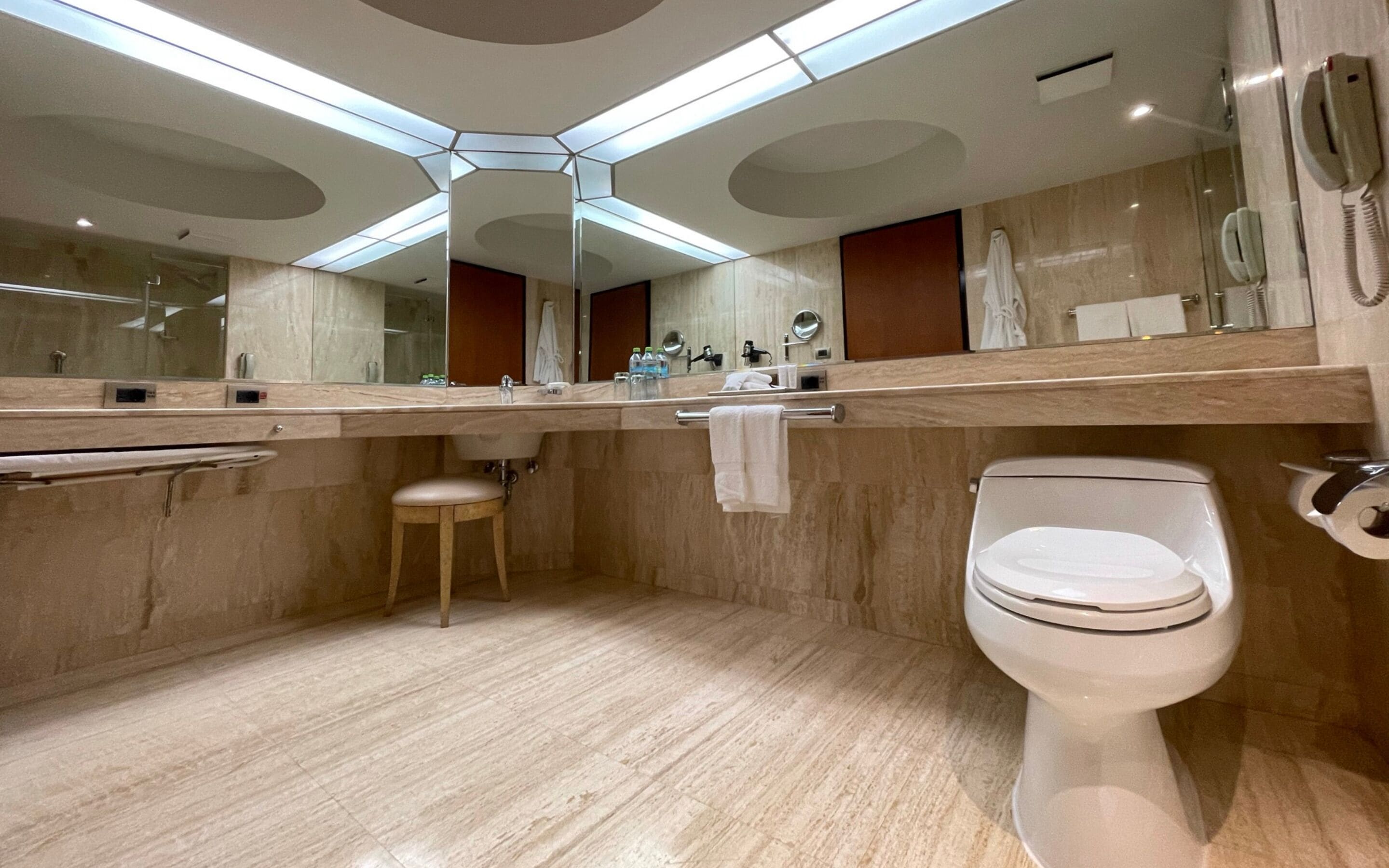 A modern bathroom with a toilet, sink, and mirror.