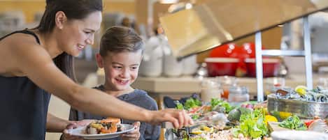 Una barra de buffet con diversos alimentos y una barra de ensaladas.