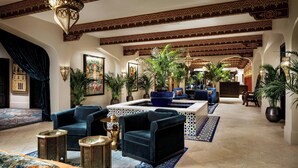 A spacious lobby with a fountain, plush seating, and decorative plants.
