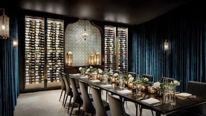 A long dining table set for a formal meal, flanked by wine racks and elegant lighting fixtures. - Casa Monica Resort & Spa, Autograph Collection (St. Augustine)