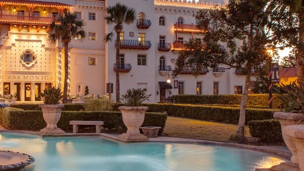 A hotel with a fountain, manicured gardens, and a well-lit facade. - Casa Monica Resort & Spa, Autograph Collection (St. Augustine)