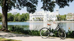 A bicycle parked by a lake with a building in the background. - The Inn at Celebration, Autograph Collection  (Celebration)