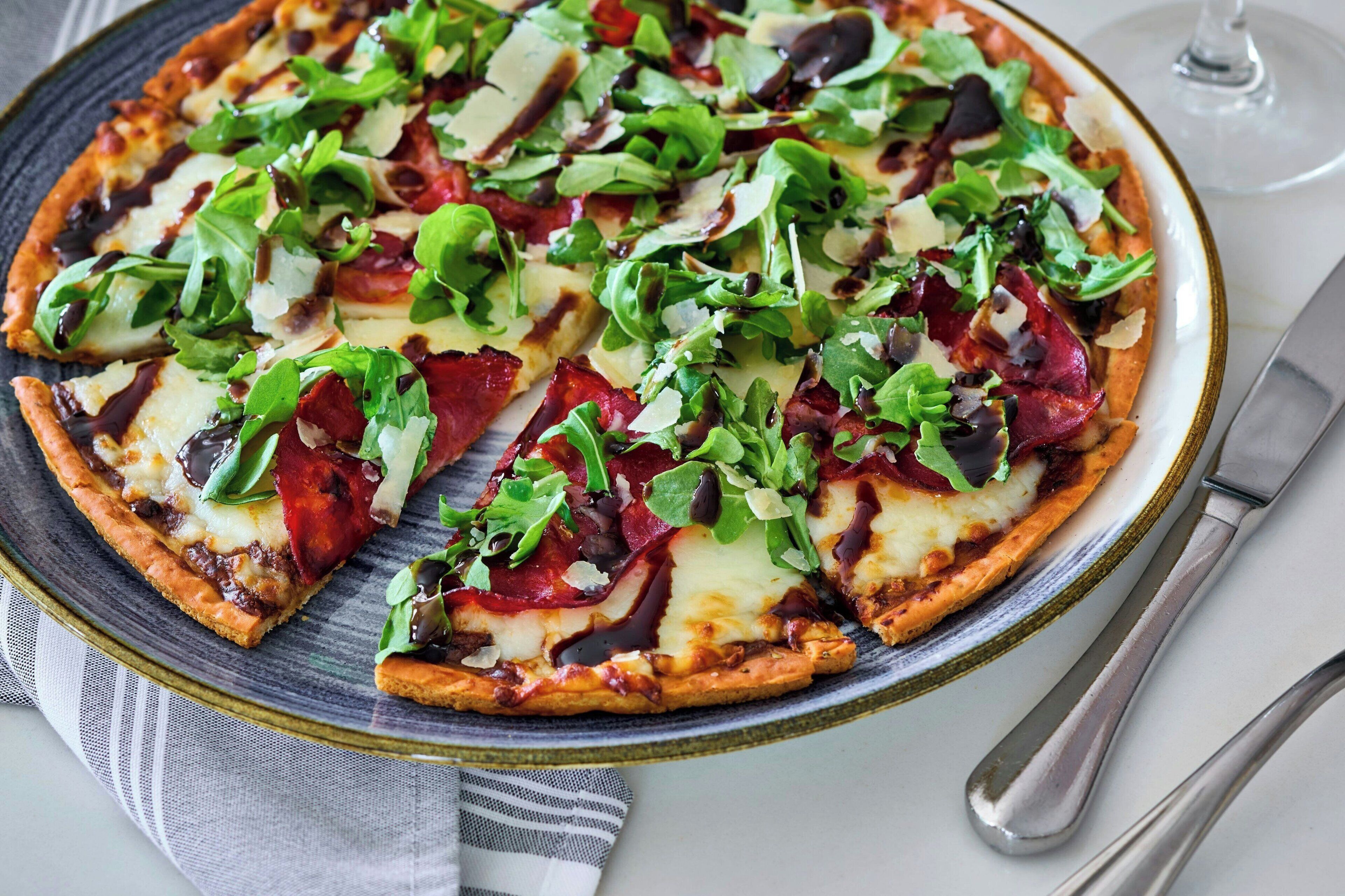 A pizza with various toppings on a plate.