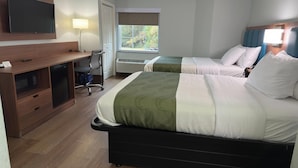 Camera d'albergo con due letti, una scrivania con una sedia, una televisione e una finestra vista alberi.