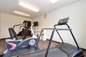 Sala de ginástica com esteira, elíptica e bicicleta ergométrica.