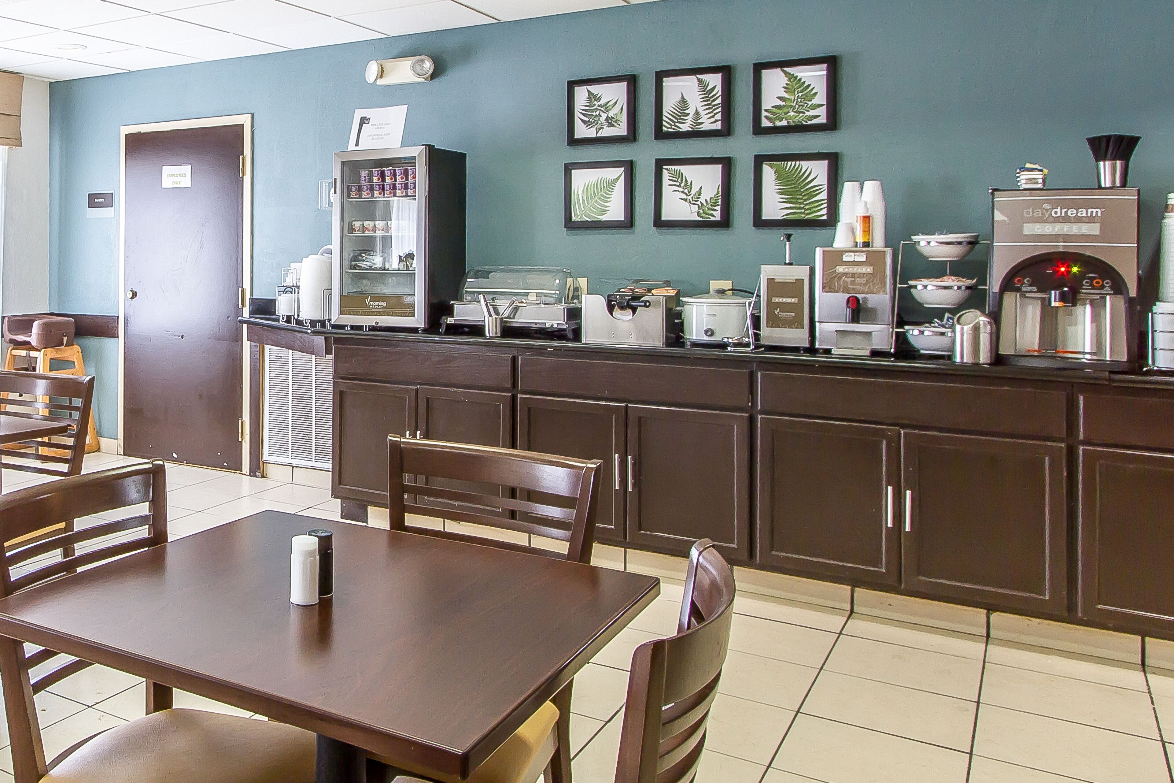 A coffee shop with a counter, seating area, and coffee machines.