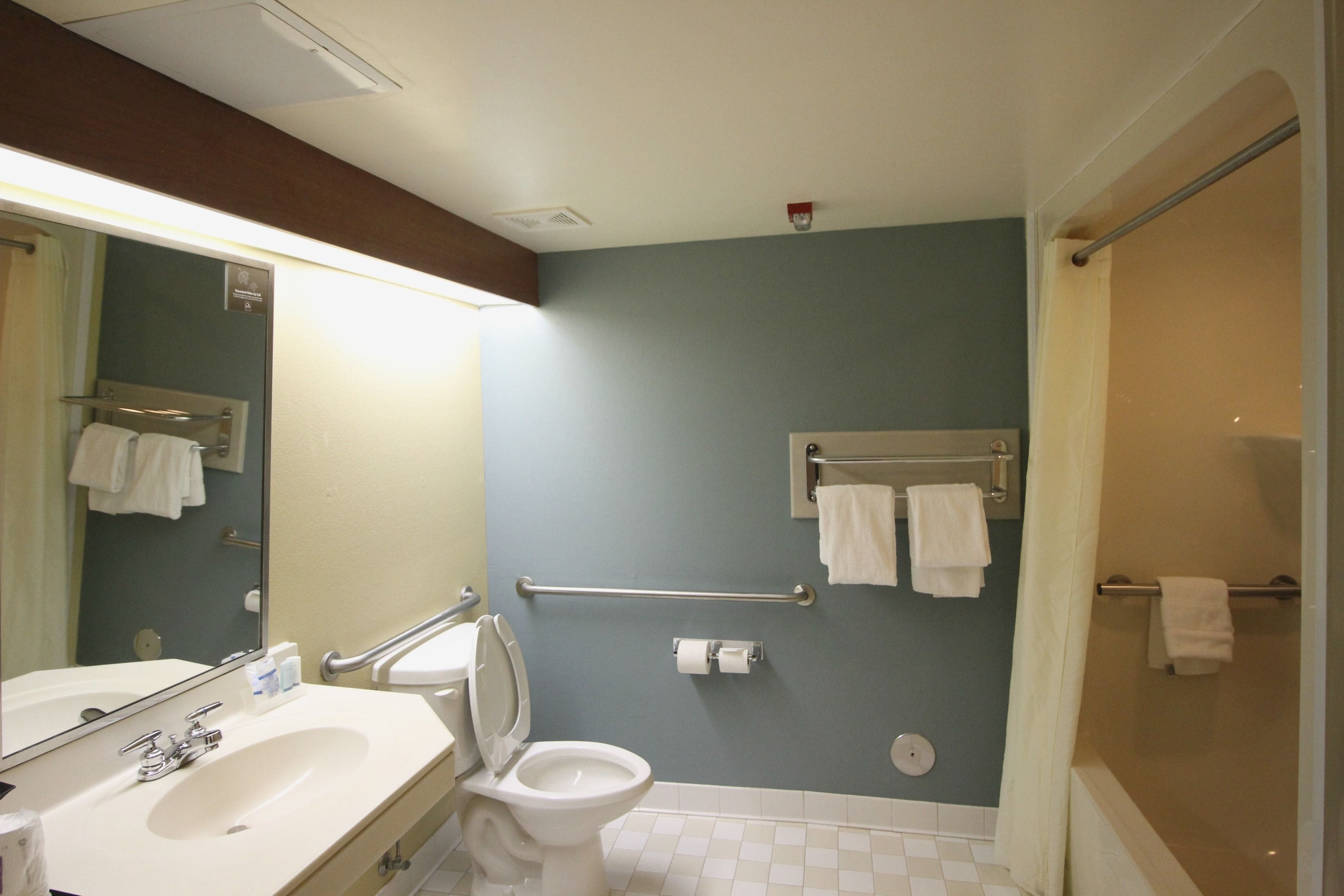 Et badeværelse med vask, toilet og brusebad.