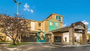 Un hôtel dont l’entrée est bien visible, qui possède un auvent vert et une enseigne indiquant qu’il s’agit d’un hôtel Clarion Point.