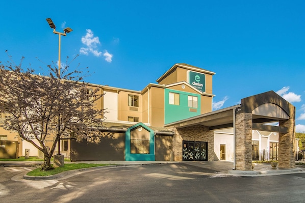 A hotel with a clear entrance, a green awning, and a sign indicating it is a Clarion Point hotel.