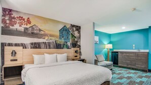 Une chambre d’hôtel avec un grand lit, un bureau, une chaise, un lavabo et une fresque murale.