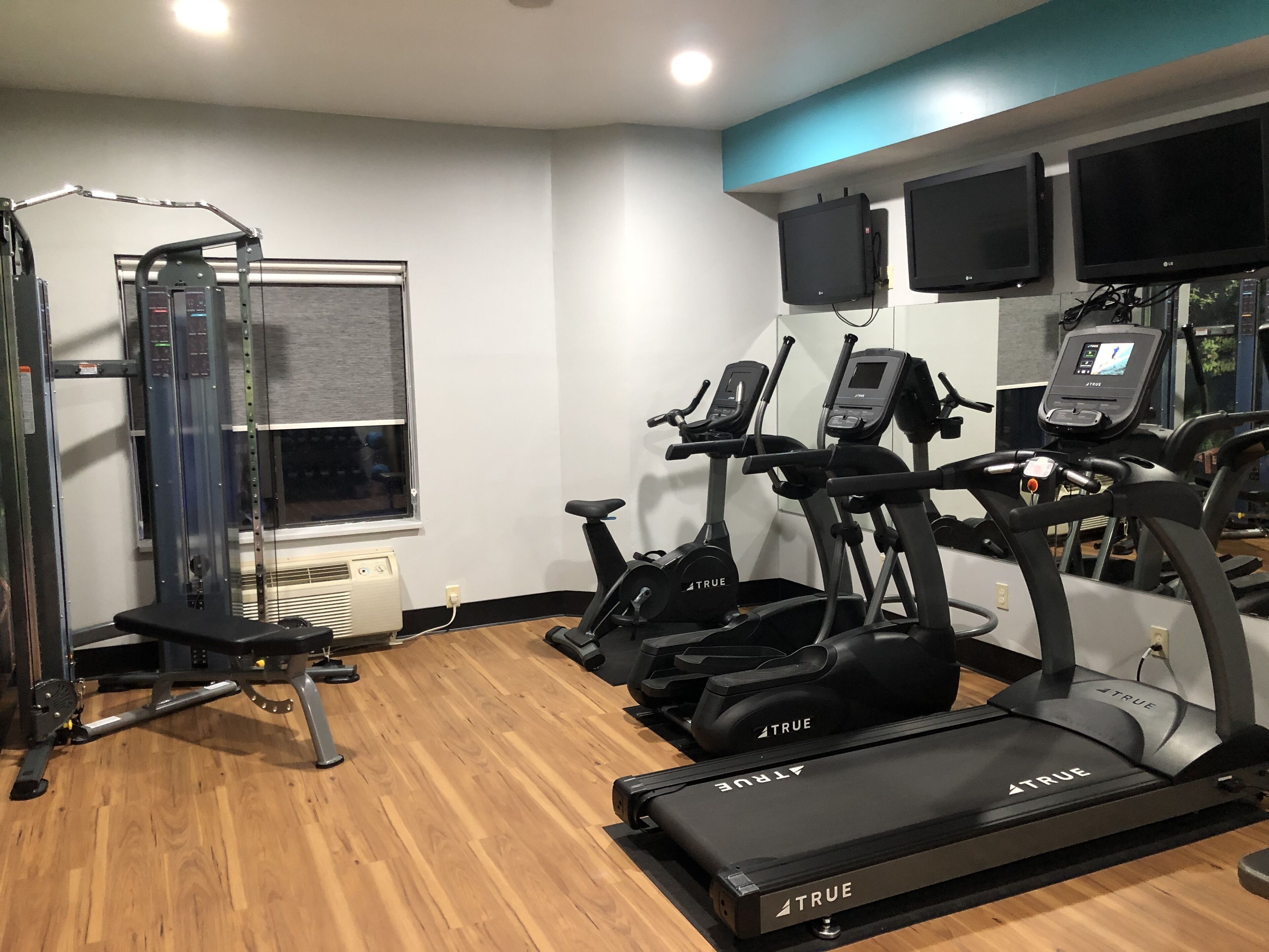 A gym with exercise equipment, including treadmills and a weight machine.