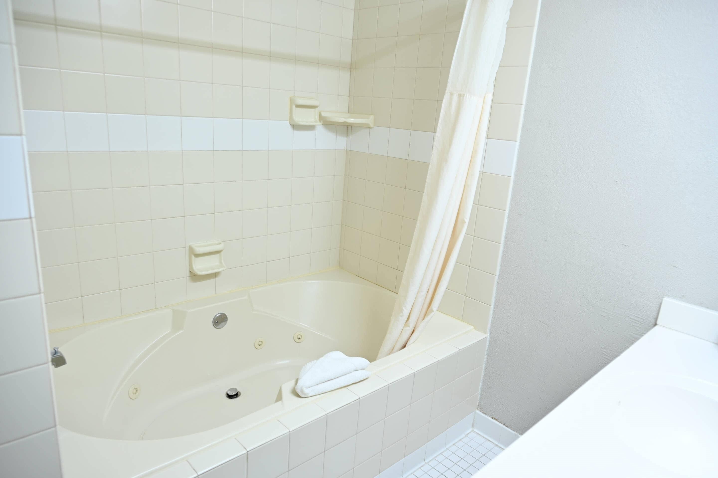 Une salle de bain avec une baignoire, un rideau de douche et une serviette.