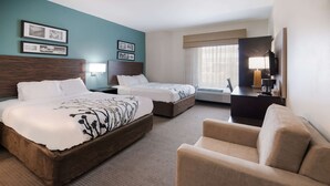 A hotel room with two beds, a sofa, a desk with a lamp, and a TV. - Sleep Inn & Suites Port Clinton (Port Clinton)