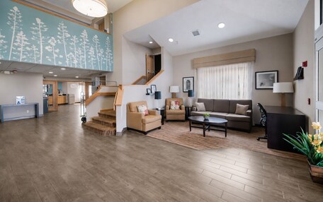 A spacious living area with a staircase, a sofa, a coffee table, and a reception desk.