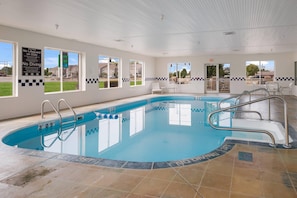 An indoor swimming pool with clear water, marked depth levels, and a no diving sign.