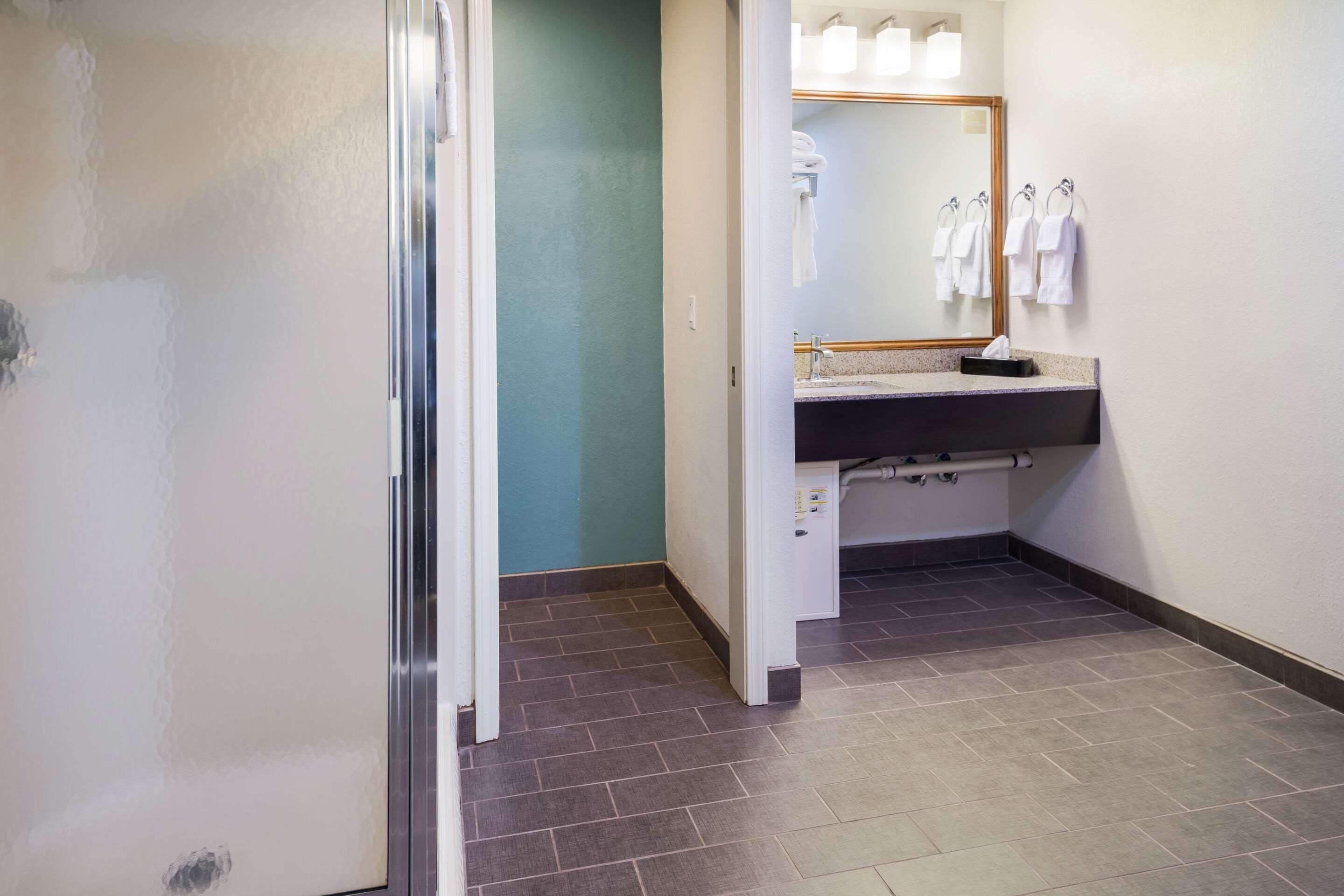 Une salle de bain équipée d’un lavabo, d’un miroir et d’un porte-serviettes.