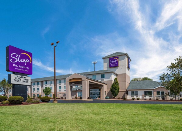 A Sleep Inn & Suites hotel with a modern design, featuring a prominent sign, a welcoming entrance, and a well-maintained lawn.