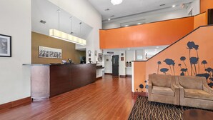A reception area with a wooden reception desk, a sofa, and a patterned rug.