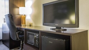A hotel room with a flat-screen TV, a desk with a lamp, a microwave, and a refrigerator. - Sleep Inn Columbia Airport (West Columbia)