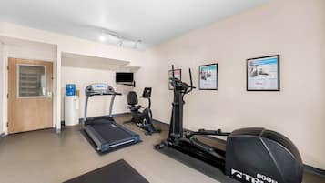 Une salle de sport équipée de tapis de course, d’un vélo elliptique et d’un vélo d’appartement.
